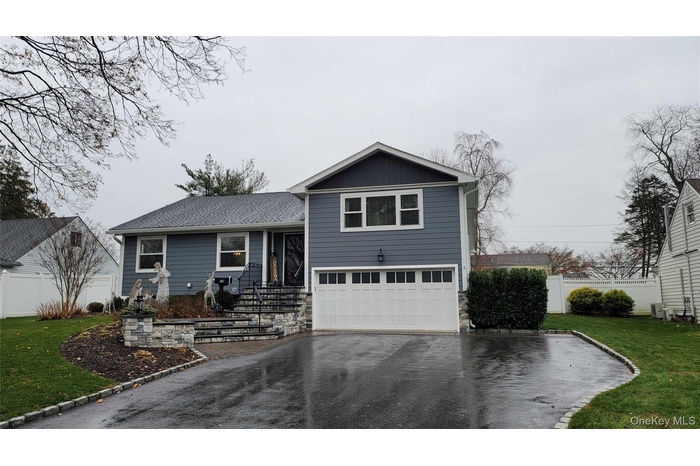 Split level home featuring driveway and an attached garage