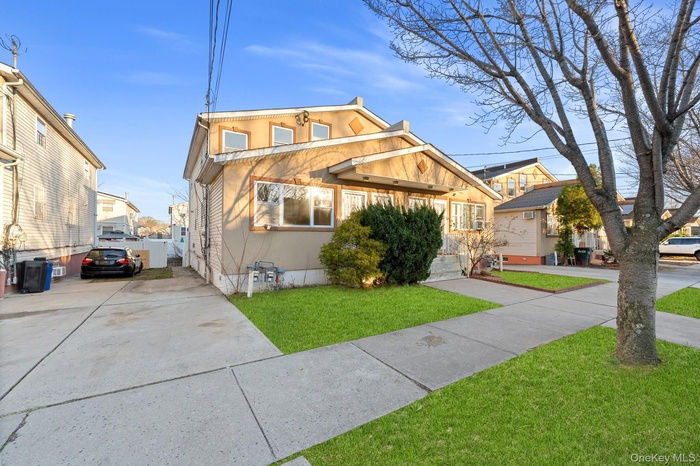 View of front facade with a front lawn and concrete driveway