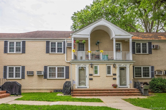 View of front of house with a balcony and brick siding