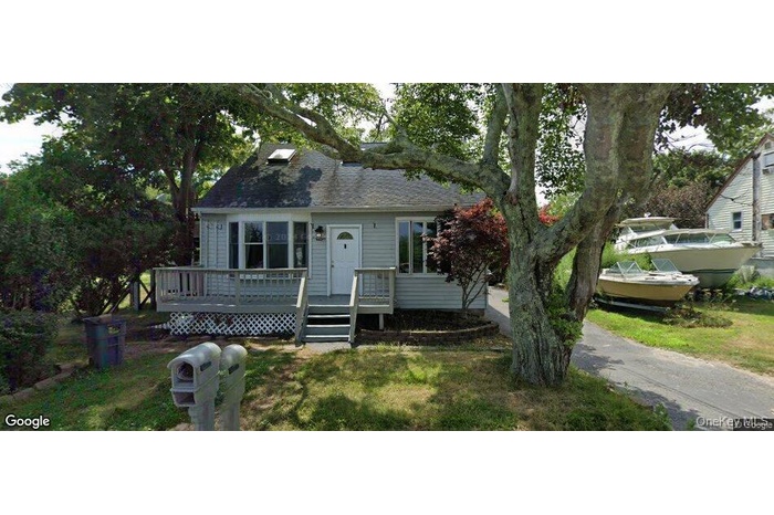 View of front of home featuring a wooden deck and a front yard