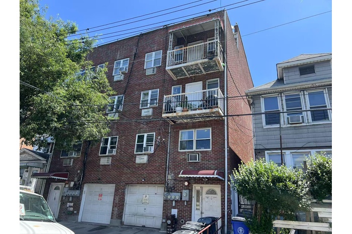 View of apartment building / complex with an attached garage and driveway