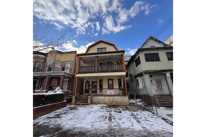 View of front facade with a gate, a fenced front yard, a balcony, and a porch and parking