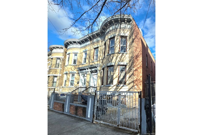 View of front facade featuring a fenced front yard, a gate, and brick siding