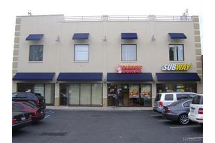 View of building exterior with uncovered parking