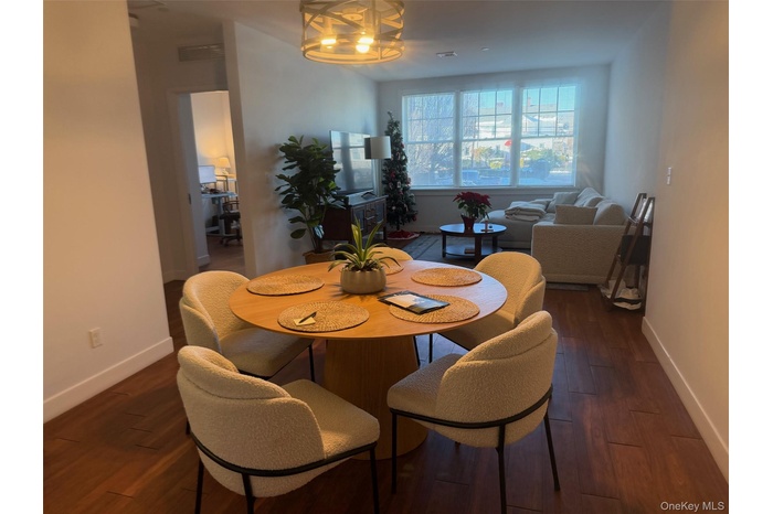 Dining space featuring baseboards and dark wood-style floors