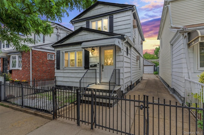 View of front facade with a fenced front yard, a garage, and a gate