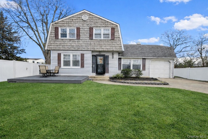 View of front of property with a gambrel roof, an attached garage, driveway, and a shingled roof