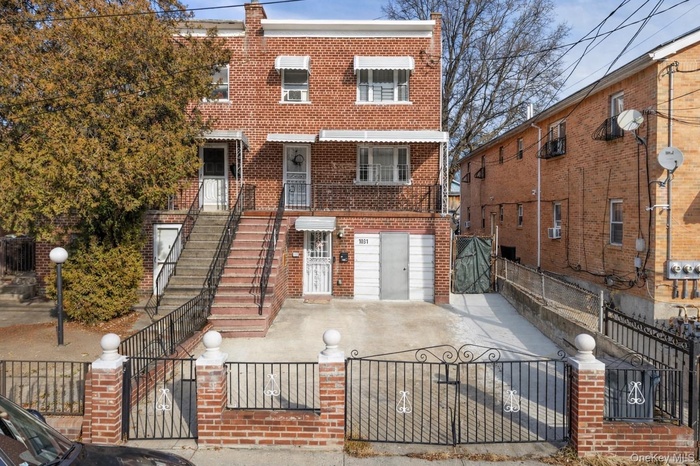 View of front of house featuring a gate, brick siding, and a fenced front yard
