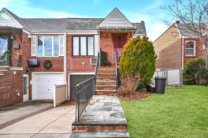 View of front facade featuring roof with shingles, brick siding, driveway, and a garage