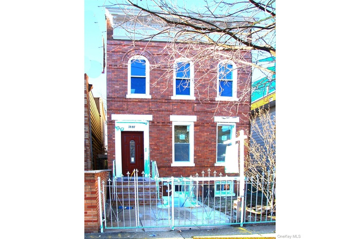 View of front of home with a fenced front yard and brick siding