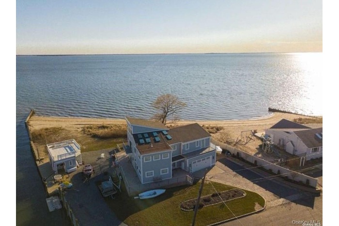 Aerial view of property and surrounding area featuring a large body of water