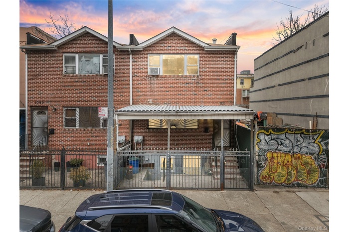 Traditional home with a fenced front yard, brick siding, and a gate