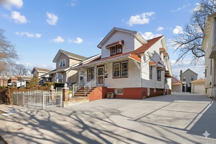 View of front of property with a gate, a porch, and a garage