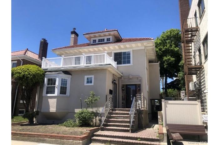 View of front facade with stucco siding and a balcony