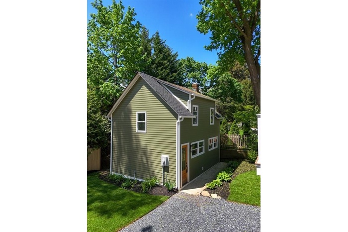 View of home's exterior with a chimney and a shingled roof