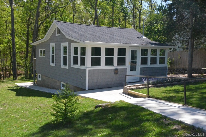 Summertime view of front of house featuring a new shingled roof