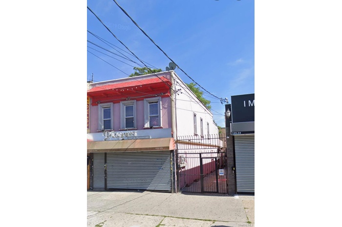 View of front of property with stucco siding and a gate