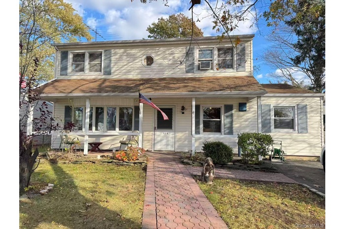View of front facade featuring a porch and a front yard