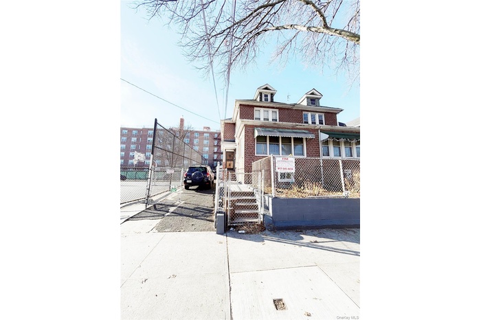 American foursquare style home with a gate, a fenced front yard, and brick siding