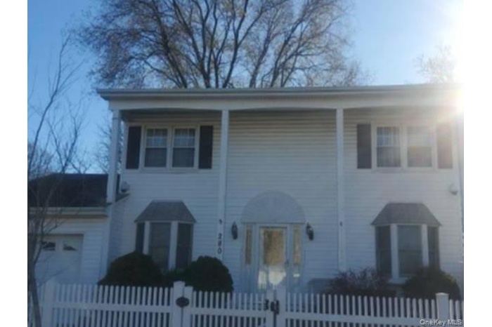 View of front of house featuring a fenced front yard and a garage