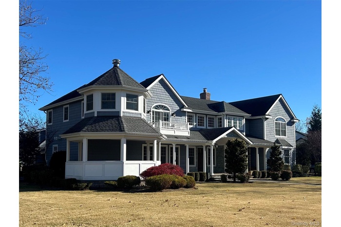 View of front of property featuring a chimney, a front yard, a porch, and a balcony