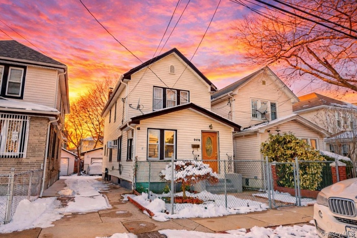 View of front of property featuring a gate, a fenced front yard, and a garage