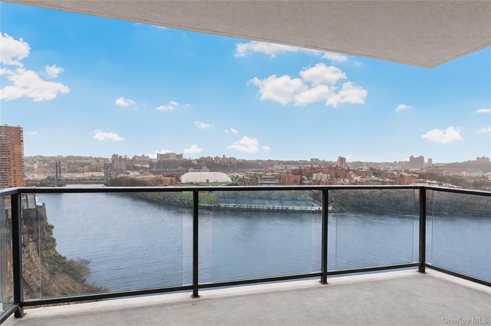 Balcony featuring a skyline view and a water view