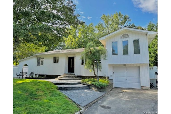 View of front of home featuring a garage and asphalt driveway