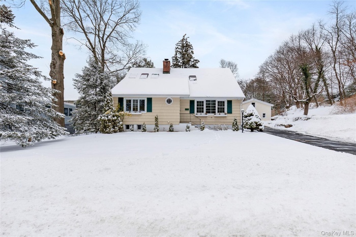Snow covered back of property with a chimney