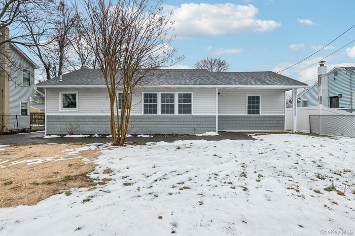 Snow covered house featuring roof with shingles