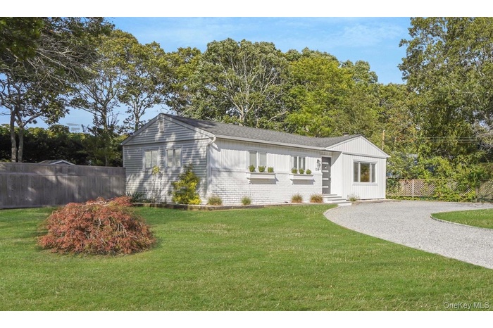 View of front of property with brick siding and view of scattered trees
