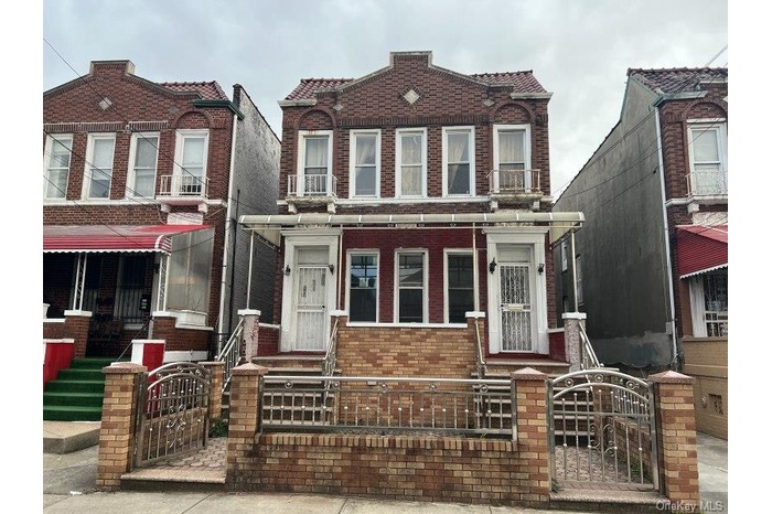 View of front facade featuring a gate, brick siding, and a fenced front yard