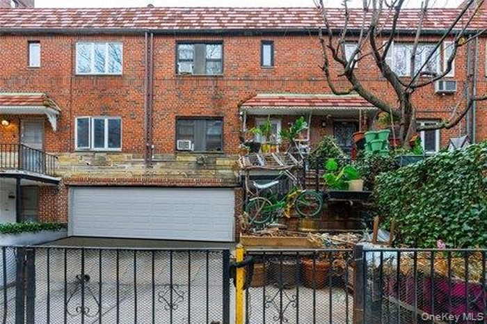 Back of house with brick siding and a balcony