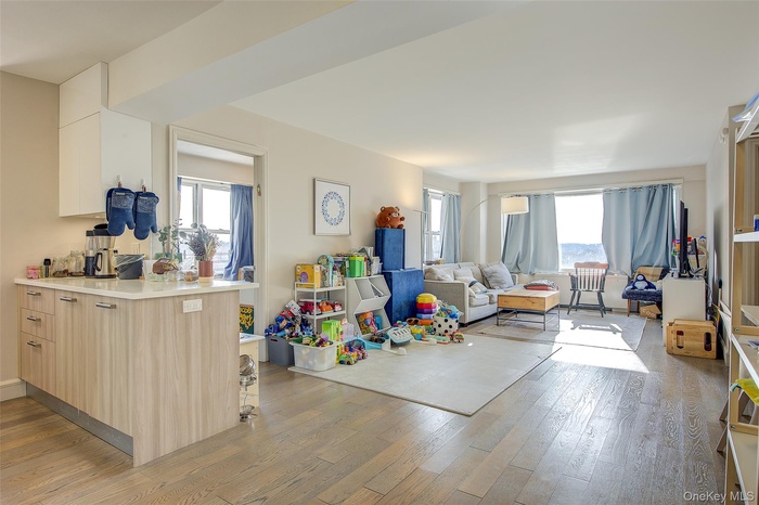 Kitchen with open floor plan, light wood-style flooring, light brown cabinets, and a peninsula