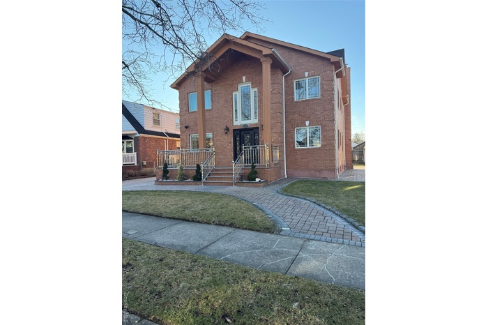 View of front of house with brick siding and a front yard