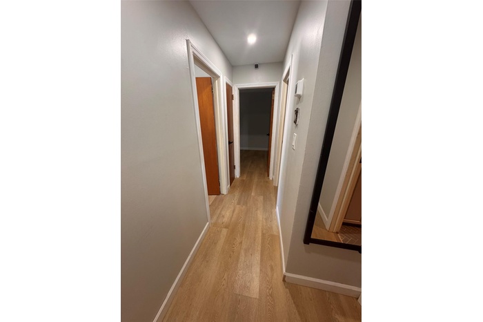 Corridor featuring baseboards and light wood-style floors