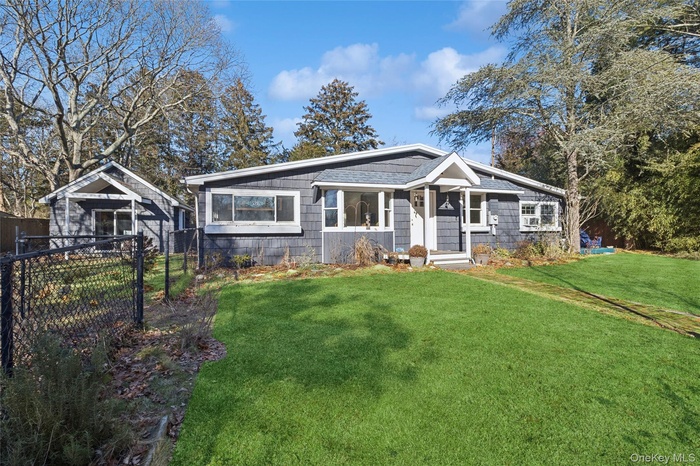 View of front of property with roof with shingles and an outbuilding