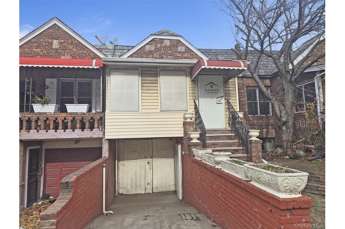 View of front of home with brick siding and an attached garage