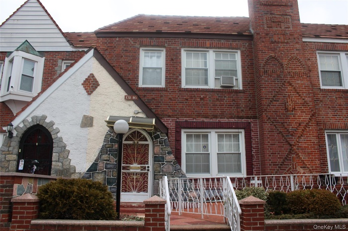 View of front of house with brick siding and a chimney