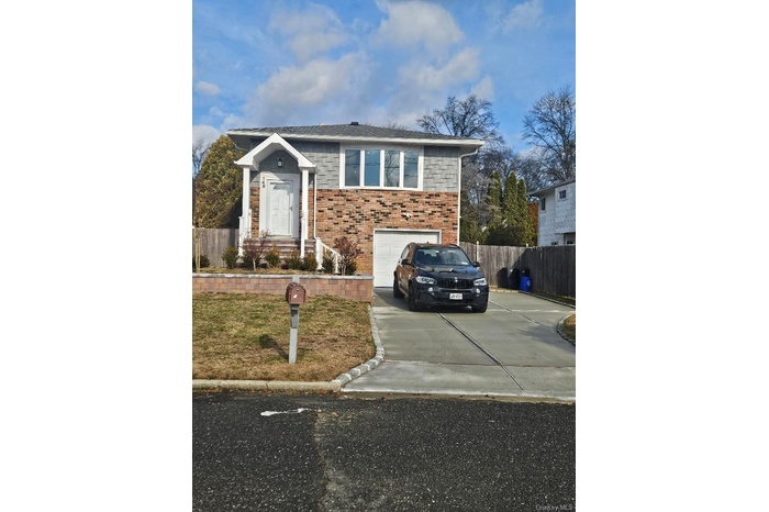 View of front of house featuring concrete driveway, a garage, and brick siding