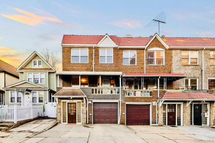 View of front of property with driveway, an attached garage, brick siding, and a residential view