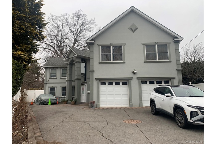 Traditional-style house featuring stucco siding, concrete driveway, an attached garage, and a shingled roof