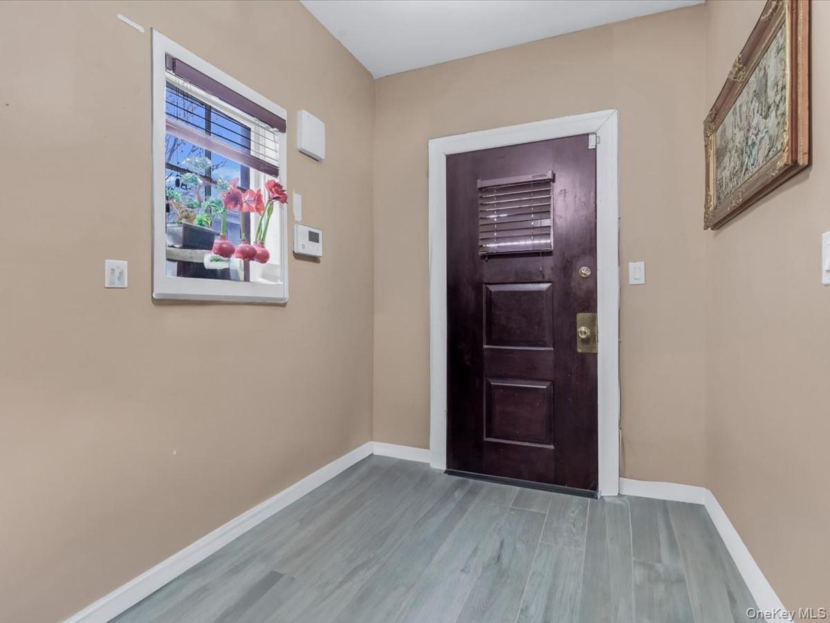 Foyer entrance featuring baseboards and wood finished floors