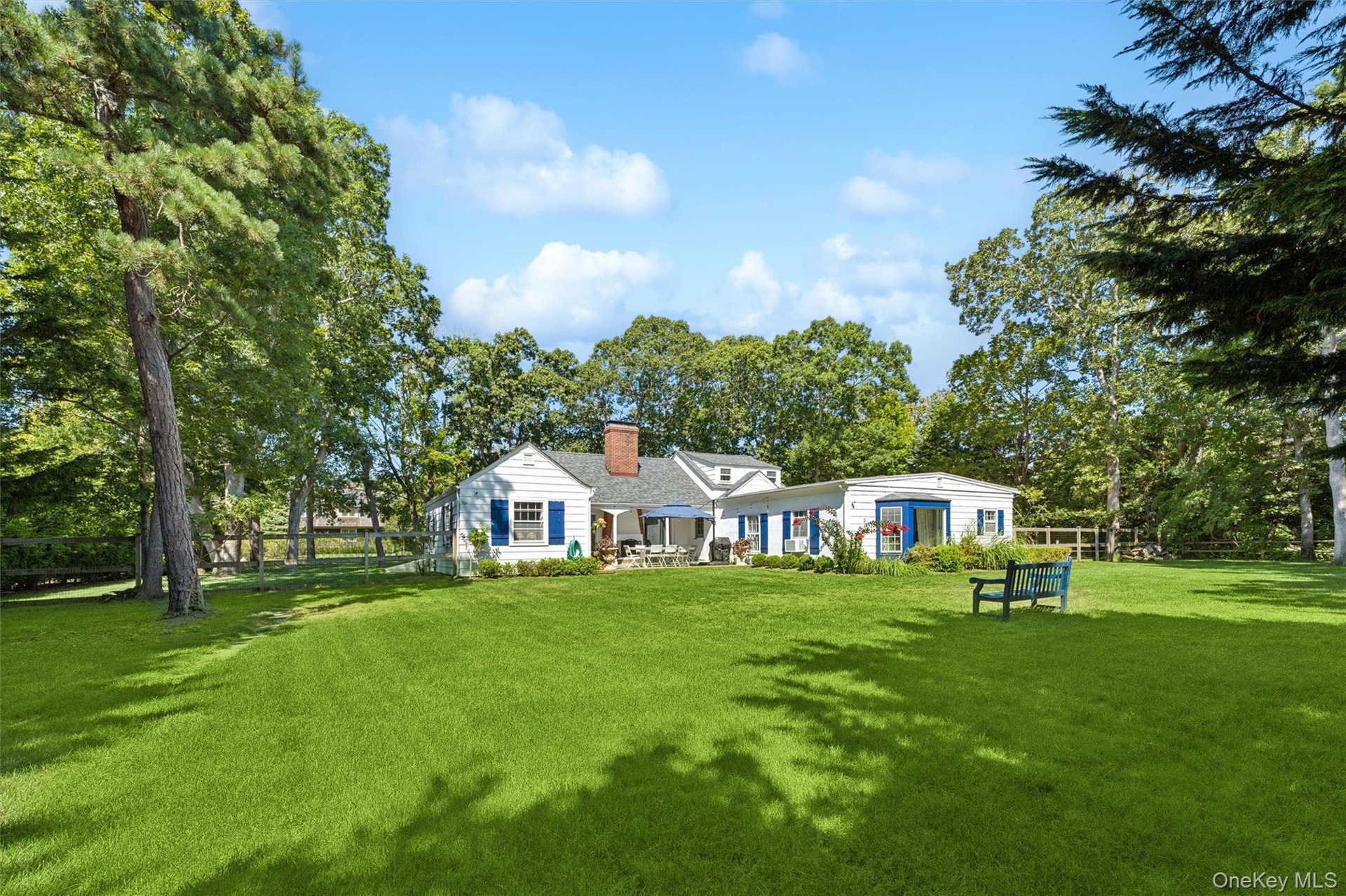 Back of house featuring a chimney and view of wooded area