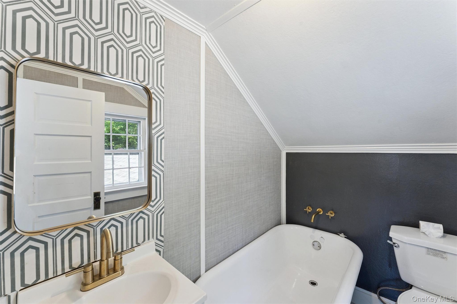 Full bathroom with a soaking tub, wallpapered walls, crown molding, and vaulted ceiling