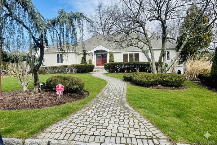 View of front of property featuring a front yard and roof with shingles