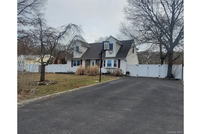 Cape cod house featuring a gate, asphalt driveway, and roof with shingles