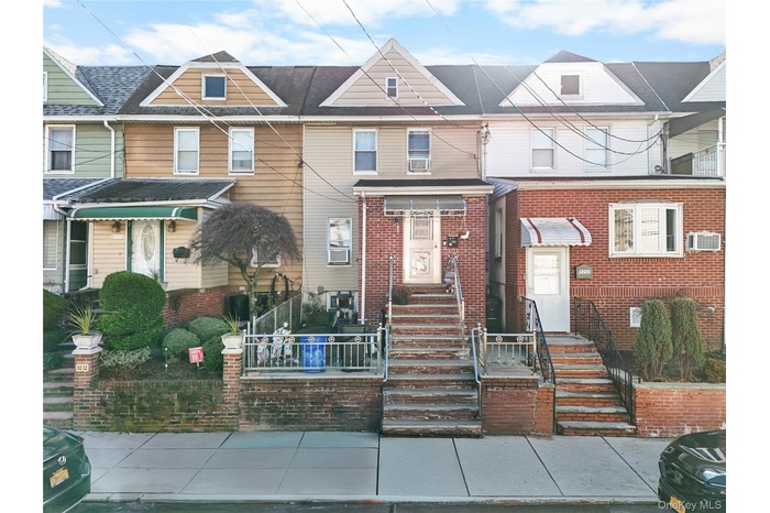 View of front of home with a fenced front yard, brick siding, and a wall unit AC