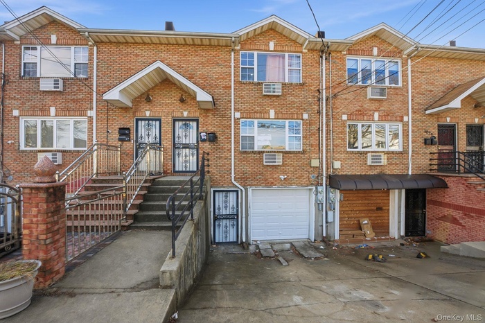 Traditional-style house featuring brick siding, an attached garage, and concrete driveway