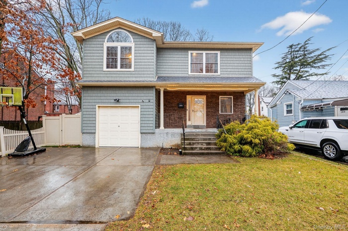 View of front facade with a porch, concrete driveway, and a garage
